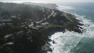 DFKSF15_064 - 5K aerial stock footage of flying by coastal neighborhoods and tilting to lighthouse, Montara, California
