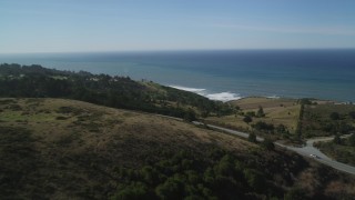 DFKSF15_085 - 5K aerial stock footage of flying over hills and a road on the coast, San Gregorio, California