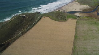 DFKSF15_117 - 5K aerial stock footage of a reverse view of farm fields on the coast, Santa Cruz, California