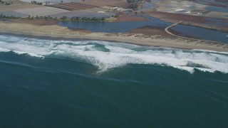 DFKSF15_146 - 5K aerial stock footage of flying by waves rolling toward a beach, Moss Landing, California