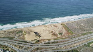 DFKSF15_152 - 5K aerial stock footage fly away from Fort Ord Dunes State Park, reveal Highway 1 coastal road, Moss Landing, California