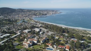 DFKSF16_003 - 5K aerial stock footage tilt from highway interchange, reveal US Naval Postgraduate School and coastal community in Monterey, California