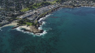 DFKSF16_009 - 5K aerial stock footage tilt from ocean kelp to reveal coastal residential neighborhoods, Monterey, California