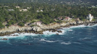 DFKSF16_025 - 5K aerial stock footage of passing by oceanfront mansions on the coast, Pebble Beach, California