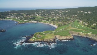 DFKSF16_034 - 5K aerial stock footage of a reverse view of a resort hotel and golf course by Carmel Bay, Pebble Beach, California