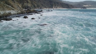 DFKSF16_080 - Aerial stock footage of 5K aerial \video of flying over the ocean, tilt up to reveal coastal cliffs, Big Sur, California