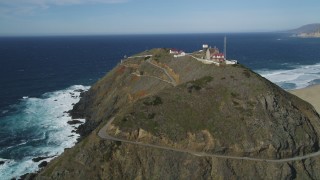 DFKSF16_091 - 5K aerial stock footage of flying around back of Point Sur Light Station, above the coastline, Big Sur, California