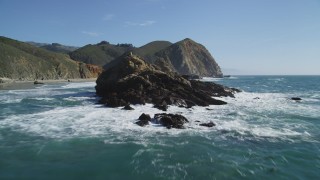 DFKSF16_104 - 5K stock footage aerial video tilt from the ocean to reveal rock formations near coastal cliffs, Big Sur, California