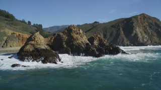 DFKSF16_105 - 5K stock footage aerial video of passing a rock formation near coastal cliffs, Big Sur, California