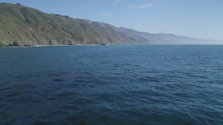 DFKSF16_107 - 5K aerial stock footage of tilting up from the ocean to reveal coastal cliffs, Big Sur, California