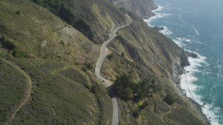 DFKSF16_116 - 5K stock footage aerial video of flying over the Highway 1 road atop coastal cliffs, tilt to cars, Big Sur, California