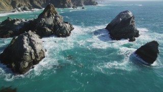 DFKSF16_122 - 5K aerial stock footage of flying between large rock formations, tilt revealing coastal cliffs, Big Sur, California