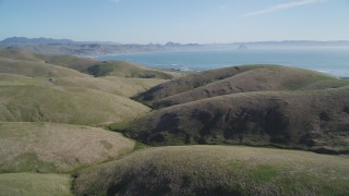 DFKSF16_152 - 5K aerial stock footage of flying over hills, revealing the coastline in Cayucos, California