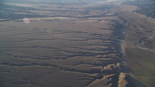 DFKSF17_024 - 5K aerial stock footage of flying by cracks in the desert and Highway 166, Cuyama Valley, California