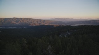 DFKSF17_053 - Aerial stock footage of 5K aerial of flying low over trees toward mountains, Los Padres National Forest, California, twilight