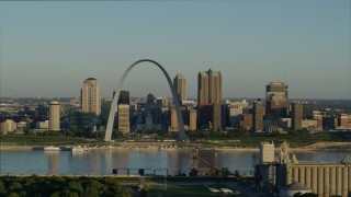 DX0001_000519 - 5.7K aerial stock footage flying over park near grain elevator approaching the Arch and skyline, sunrise, Downtown St. Louis, Missouri
