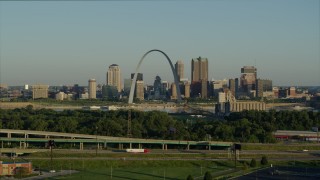 DX0001_000522 - 5.7K aerial stock footage descending below the interstate looking toward the Arch and skyline, sunrise, Downtown St. Louis, Missouri