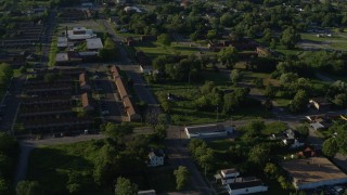 DX0001_000561 - 5.7K aerial stock footage approaching apartment buildings among trees, sunrise, East St Louis, Illinois