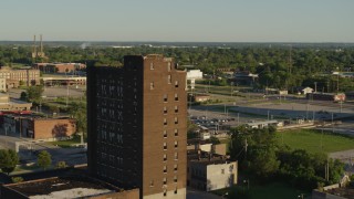 DX0001_000671 - 5.7K aerial stock footage orbiting the top of an abandoned office building at sunset in East St. Louis, Illinois