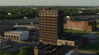 DX0001_000674 - 5.7K aerial stock footage of flying away from an abandoned office building at sunset, East St. Louis, Illinois