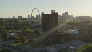 DX0001_000678 - 5.7K aerial stock footage approach a brick building at sunset in East St. Louis, Illinois with the Gateway Arch in background