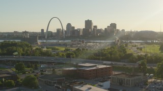 DX0001_000679 - 5.7K stock footage aerial video fly over brick building at sunset toward Gateway Arch and Downtown St. Louis, Missouri