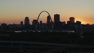 DX0001_000728 - 5.7K aerial stock footage ascend and approach the Gateway Arch and Downtown St. Louis, Missouri skyline in silhouette at sunset
