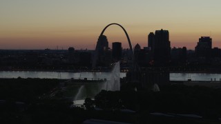 DX0001_000760 - 5.7K aerial stock footage of the Gateway Arch beyond the Gateway Geyser in Downtown St. Louis, Missouri, twilight