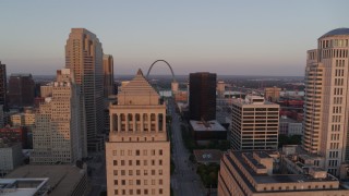 DX0001_000868 - 5.7K aerial stock footage of a static then reverse view of the Arch seen over a courthouse at sunset, Downtown St. Louis, Missouri