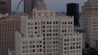 DX0001_000888 - 5.7K aerial stock footage of circling the top of a downtown apartment building at twilight, Downtown St. Louis, Missouri