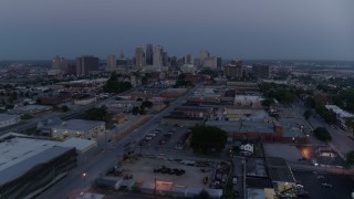 DX0001_000978 - 5.7K aerial stock footage fly over industrial area to approach skyline at twilight, Downtown Kansas City, Missouri