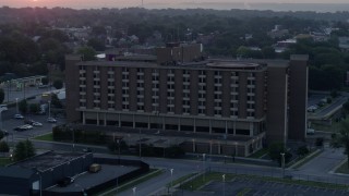 DX0001_000990 - 5.7K aerial stock footage of orbiting a brick office building at sunrise in Kansas City, Missouri
