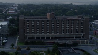 DX0001_000991 - 5.7K aerial stock footage of orbiting around a brick office building at sunrise in Kansas City, Missouri
