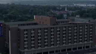 DX0001_000992 - 5.7K aerial stock footage of circling around a brick office building at sunrise in Kansas City, Missouri