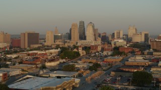 DX0001_001008 - 5.7K aerial stock footage flyby and away from the city skyline at sunrise, seen from an industrial area, Downtown Kansas City, Missouri