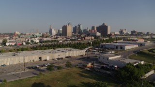DX0001_001046 - 5.7K aerial stock footage of descend toward warehouse buildings, freeway near skyline of Downtown Kansas City, Missouri