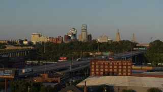 DX0001_001166 - 5.7K aerial stock footage flying by freeway with light traffic with view of skyline at sunset in Downtown Kansas City, Missouri