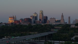 DX0001_001179 - 5.7K aerial stock footage of city skyline reflecting the setting sun in Downtown Kansas City, Missouri, seen from I-670, twilight