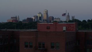 DX0001_001198 - 5.7K stock footage aerial video ascend by brick building at twilight, reveal skyline of Downtown Kansas City, Missouri