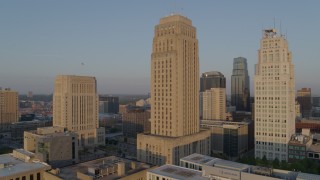 DX0001_001212 - 5.7K aerial stock footage of a reverse view of city hall and skyscraper at sunrise, Downtown Kansas City, Missouri
