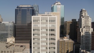 DX0001_001279 - 5.7K aerial stock footage of flying away from a downtown office building at sunrise, Downtown Kansas City, Missouri