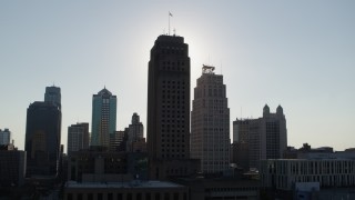 DX0001_001330 - 5.7K aerial stock footage of the sun behind city hall and skyscraper in Downtown Kansas City, Missouri