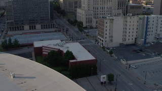 DX0001_001343 - 5.7K aerial stock footage of three cars stopped at a light at sunset in Downtown Kansas City, Missouri