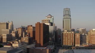 DX0001_001347 - 5.7K aerial stock footage of the setting sun shining on city skyscrapers in Downtown Kansas City, Missouri