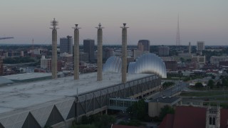 DX0001_001358 - 5.7K aerial stock footage of passing the convention center to approach concert hall at sunset in Downtown Kansas City, Missouri