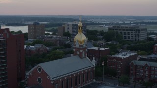 DX0001_001361 - 5.7K aerial stock footage of circling a brick cathedral's steeple at sunset in Downtown Kansas City, Missouri