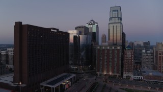DX0001_001380 - 5.7K aerial stock footage of flying away from hotel and skyscrapers at twilight in Downtown Kansas City, Missouri