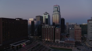 DX0001_001382 - 5.7K aerial stock footage of a downtown hotel and tall city skyscrapers at twilight in Downtown Kansas City, Missouri