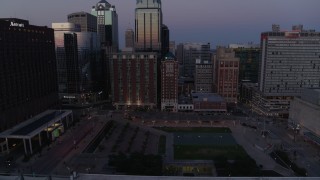 DX0001_001383 - 5.7K stock footage aerial video ascend from near park for a view of city skyscrapers at twilight in Downtown Kansas City, Missouri