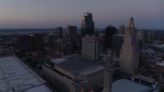 DX0001_001384 - 5.7K aerial stock footage of city skyscrapers lit up for the evening at twilight in Downtown Kansas City, Missouri